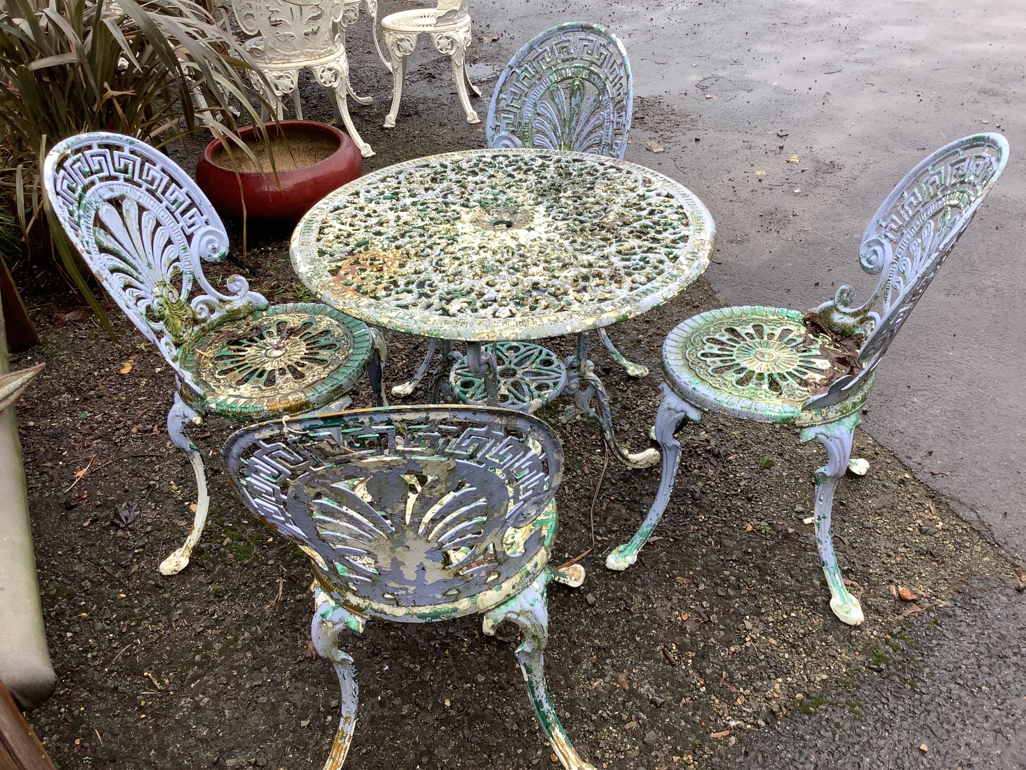 A Victorian style cast aluminium garden table, diameter 71cm, height 67cm, together with four chairs